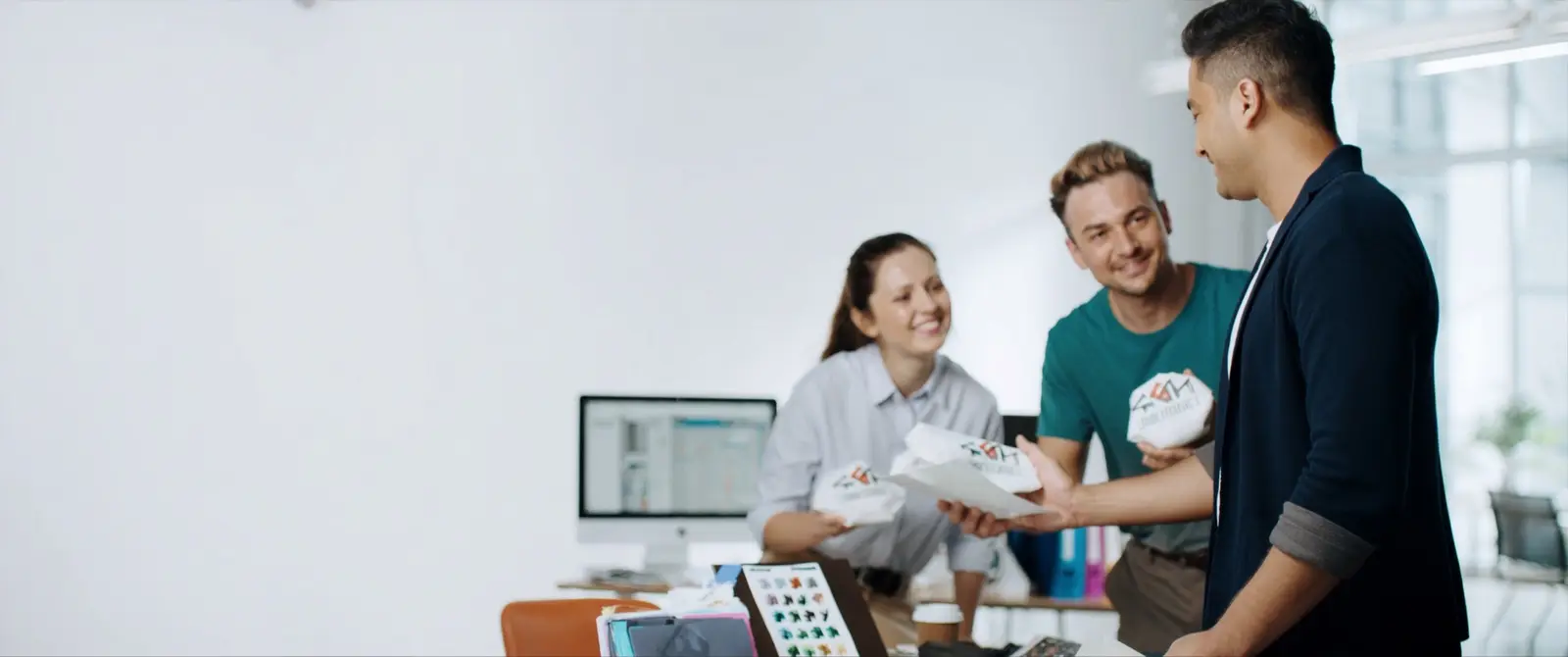 The Genesis team reviewing branded merchandise